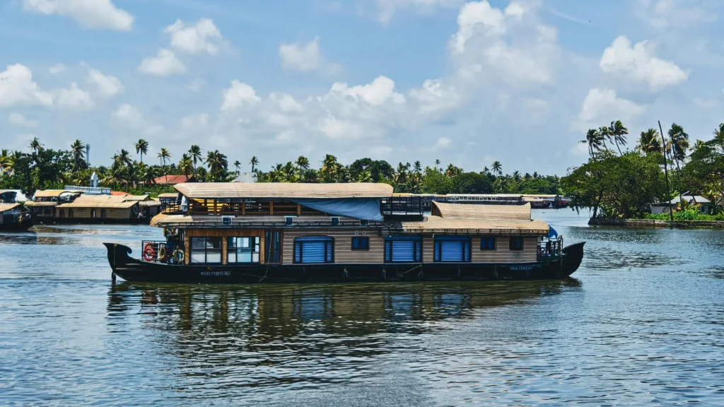 Kumarakom backwaters in Kerala with houseboats cruising on calm lake waters.